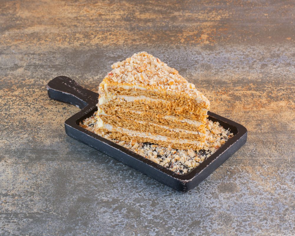 Close up photo of cake slice on wooden board on rustic background. High quality photo